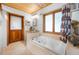 Bright bathroom featuring a jacuzzi tub, wood door, vanity, and large window at 2760 Lemon Ave, Englewood, FL 34223
