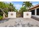Courtyard with an iron gate, landscaping and mature palms at 2760 Lemon Ave, Englewood, FL 34223