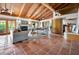 Open living room boasts a vaulted ceiling, wood beams, tile flooring, and large windows, perfect for entertaining at 2760 Lemon Ave, Englewood, FL 34223