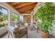 Relaxing covered patio featuring stylish furniture, wood ceiling with fan, and views of the lush backyard at 2760 Lemon Ave, Englewood, FL 34223
