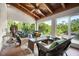 Bright screened porch with wood ceiling, wicker seating, a glass coffee table, and lush greenery views at 2760 Lemon Ave, Englewood, FL 34223