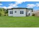 Expansive backyard showcasing a well-maintained lawn and covered patio with stylish design at 280 Antis Dr, Rotonda West, FL 33947