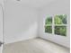 Bright bedroom featuring wood-look tile flooring and a large window showcasing lush greenery at 280 Antis Dr, Rotonda West, FL 33947