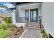 Charming front entrance featuring gray door, brick stairs, and landscaped garden at 280 Antis Dr, Rotonda West, FL 33947