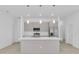 Modern kitchen with an island, stainless steel appliances, and stylish pendant lighting at 280 Antis Dr, Rotonda West, FL 33947