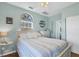 Bright bedroom with light blue walls, light wood floor, window and nautical decor at 310 Kettle Harbor Dr, Placida, FL 33946