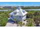 Beautiful elevated coastal home featuring a charming cupola and balcony overlooking lush tropical landscaping at 310 Kettle Harbor Dr, Placida, FL 33946