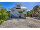 Coastal home featuring elevated construction, a charming tower, and surrounded by lush tropical landscaping at 310 Kettle Harbor Dr, Placida, FL 33946