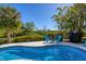 Relaxing pool deck with two blue chairs overlooking tropical trees and landscaping at 310 Kettle Harbor Dr, Placida, FL 33946