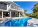 Inviting backyard pool with a sun deck, white railing and stairs, and lush tropical landscaping at 310 Kettle Harbor Dr, Placida, FL 33946