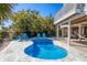 Private kidney-shaped pool with a tiled surround, lounge chairs, and palm trees creating a tranquil outdoor space at 310 Kettle Harbor Dr, Placida, FL 33946