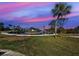 Colorful sunset view of the community waterway with a palm tree in the foreground at 408 S Mccall Rd, Englewood, FL 34223