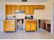 Bright kitchen featuring wood cabinets, tile flooring, and damaged walls at 408 S Mccall Rd, Englewood, FL 34223