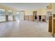 Open-concept living room featuring tile flooring, multiple windows, and damaged walls at 408 S Mccall Rd, Englewood, FL 34223