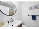 Bright bathroom with a modern vanity, black faucet, circular mirror and lovely decorations throughout at 4410 Warren Ave # 217, Port Charlotte, FL 33953