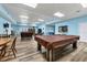 Spacious clubhouse with a pool table and seating areas on stylish wood flooring, bathed in natural light at 4410 Warren Ave # 217, Port Charlotte, FL 33953