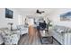 Open-concept living room with hardwood floors, ceiling fan, striped sofa, and open view to kitchen at 4410 Warren Ave # 217, Port Charlotte, FL 33953