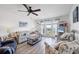 Bright living room with hardwood floors, ceiling fan, striped sofa, and balcony with water views at 4410 Warren Ave # 217, Port Charlotte, FL 33953