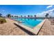 Beautiful community pool with clear blue water, surrounded by palm trees and lounge chairs on a sunny day at 4410 Warren Ave # 217, Port Charlotte, FL 33953