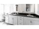 This main bathroom features a vanity with dual sinks, white cabinets, and stunning black countertop at 52 Mariner Ln, Rotonda West, FL 33947