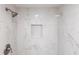 Sleek walk-in shower enclosed with beautiful marble tiles and a small built-in shelf at 52 Mariner Ln, Rotonda West, FL 33947