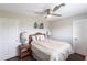 Cozy bedroom features light walls, a ceiling fan, wood floors, and matching nightstands with lamps at 52 Mariner Ln, Rotonda West, FL 33947