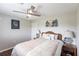 Comfortable bedroom showcasing a ceiling fan, wood floors, and matching nightstands with lamps at 52 Mariner Ln, Rotonda West, FL 33947