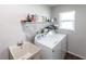 A well-equipped laundry room with a utility sink, washer, dryer, and storage shelf above at 52 Mariner Ln, Rotonda West, FL 33947