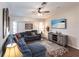 Comfortable living room with a blue sectional sofa, ceiling fan, and a wall-mounted television at 52 Mariner Ln, Rotonda West, FL 33947