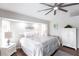 Bright and airy main bedroom boasts a plush rug, ceiling fan, and decorative art above the headboard at 52 Mariner Ln, Rotonda West, FL 33947