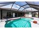 Relaxing screened-in pool and deck area with an outdoor kitchen and seating space at 52 Mariner Ln, Rotonda West, FL 33947