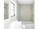A clean and modern bathroom with white tiled walls and a bathtub with shower at 5266 Cooper Ter, Port Charlotte, FL 33981