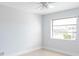 A brightly lit bedroom with a ceiling fan and a window, featuring tiled floors at 5266 Cooper Ter, Port Charlotte, FL 33981