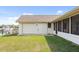 Exterior shot of the home with a well-maintained lawn, attached garage, and screened in patio at 5266 Cooper Ter, Port Charlotte, FL 33981