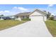 An inviting exterior showcasing a well-maintained lawn, a spacious driveway, and an attached garage at 5266 Cooper Ter, Port Charlotte, FL 33981