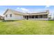 Back exterior of home with solar panels, screened in patio, attached garage and a lush backyard at 5266 Cooper Ter, Port Charlotte, FL 33981