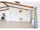 Vaulted ceilings with wood beams add character to this living room with neutral paint and floors at 5266 Cooper Ter, Port Charlotte, FL 33981