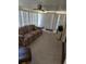 Living room featuring a sofa, large windows with vertical blinds, carpeted floors, and ceiling fan at 6162 Redwing Ave, Englewood, FL 34224