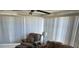 Living room with a sofa, arm chair, lamp, carpeted floors, and a large window with vertical blinds at 6162 Redwing Ave, Englewood, FL 34224