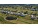 Sweeping aerial view showing a residential area adjacent to a golf course, complete with ponds and beautiful landscaping at 62 Oakland Hills Pl, Rotonda West, FL 33947