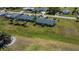 This aerial view displays a home with a screened lanai and fenced yard, surrounded by lush green space at 62 Oakland Hills Pl, Rotonda West, FL 33947