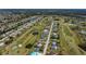 Expansive aerial view capturing a community with homes bordering a golf course with winding paths and serene water features at 62 Oakland Hills Pl, Rotonda West, FL 33947