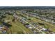 An expansive aerial view of a residential area situated next to a golf course with ponds and waterways at 62 Oakland Hills Pl, Rotonda West, FL 33947