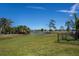 A serene backyard view showcasing lush green grass and a tranquil pond, perfect for relaxation and enjoying nature at 62 Oakland Hills Pl, Rotonda West, FL 33947