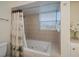Bathroom with a jetted tub, tiled surround, and a bright window for natural light at 62 Oakland Hills Pl, Rotonda West, FL 33947