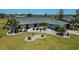 Well-maintained home with a landscaped front yard, gray roof, manicured lawn, and fresh exterior paint at 62 Oakland Hills Pl, Rotonda West, FL 33947