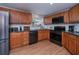 Well-lit kitchen with wooden cabinets, stainless steel appliances, and wood flooring at 62 Oakland Hills Pl, Rotonda West, FL 33947