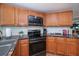 Bright kitchen with wooden cabinets, stainless steel appliances, granite countertops, and a window at 62 Oakland Hills Pl, Rotonda West, FL 33947