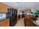 Spacious kitchen featuring wood cabinets, granite countertops, stainless steel appliances, and wood flooring at 62 Oakland Hills Pl, Rotonda West, FL 33947