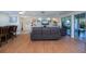 Bright living room featuring wood floors, gray sofa, built-in shelving, and sliding glass doors at 62 Oakland Hills Pl, Rotonda West, FL 33947
